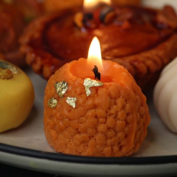 Handmade Motichoor Laddoo-shaped candles crafted from eco-friendly soy wax — ideal for festive décor, gifting, and puja setups.